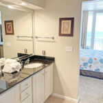 master bathroom with two sinks and view of master bedroom with sliding doors overlooking gulf shores beach